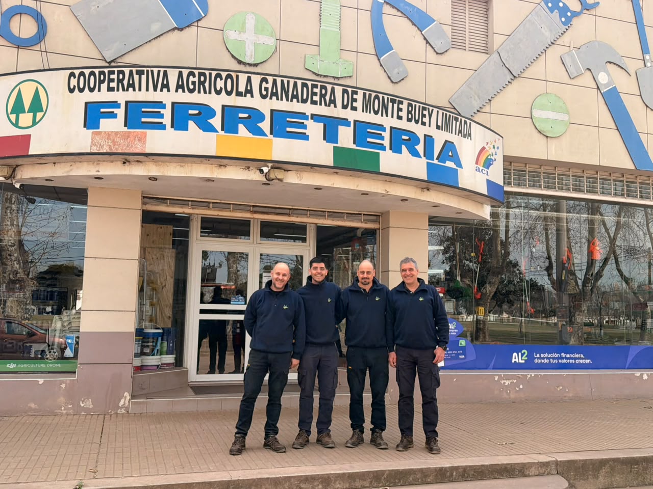 Los cuatro integrantes del equipo de Ferretería y Corralón frente al local de la Cooperativa